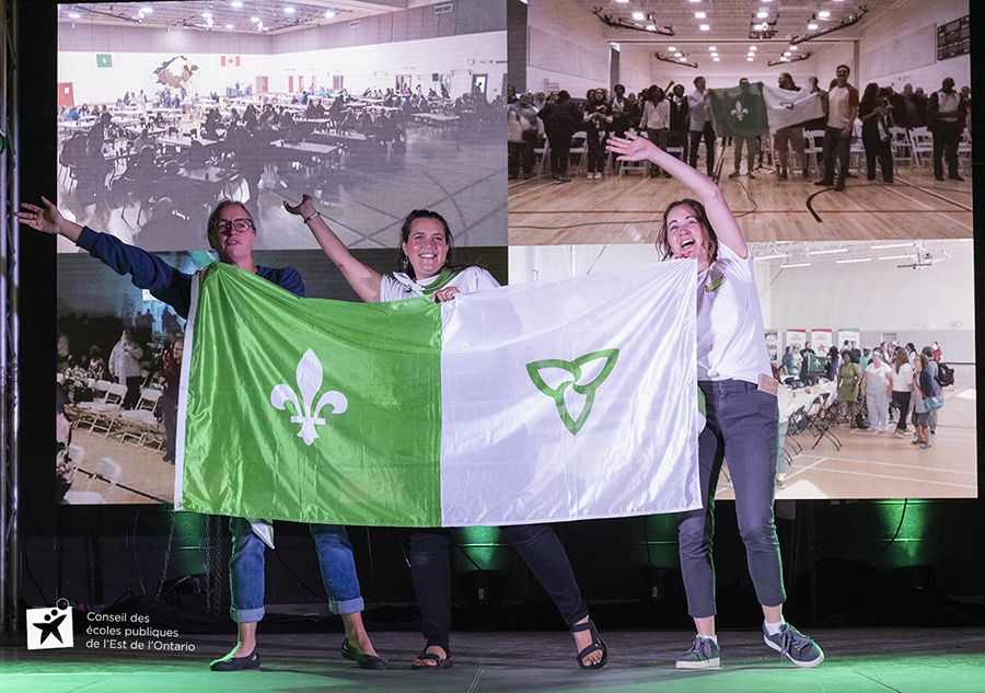 Trois dames dansant avec le drapeau franco-ontarien