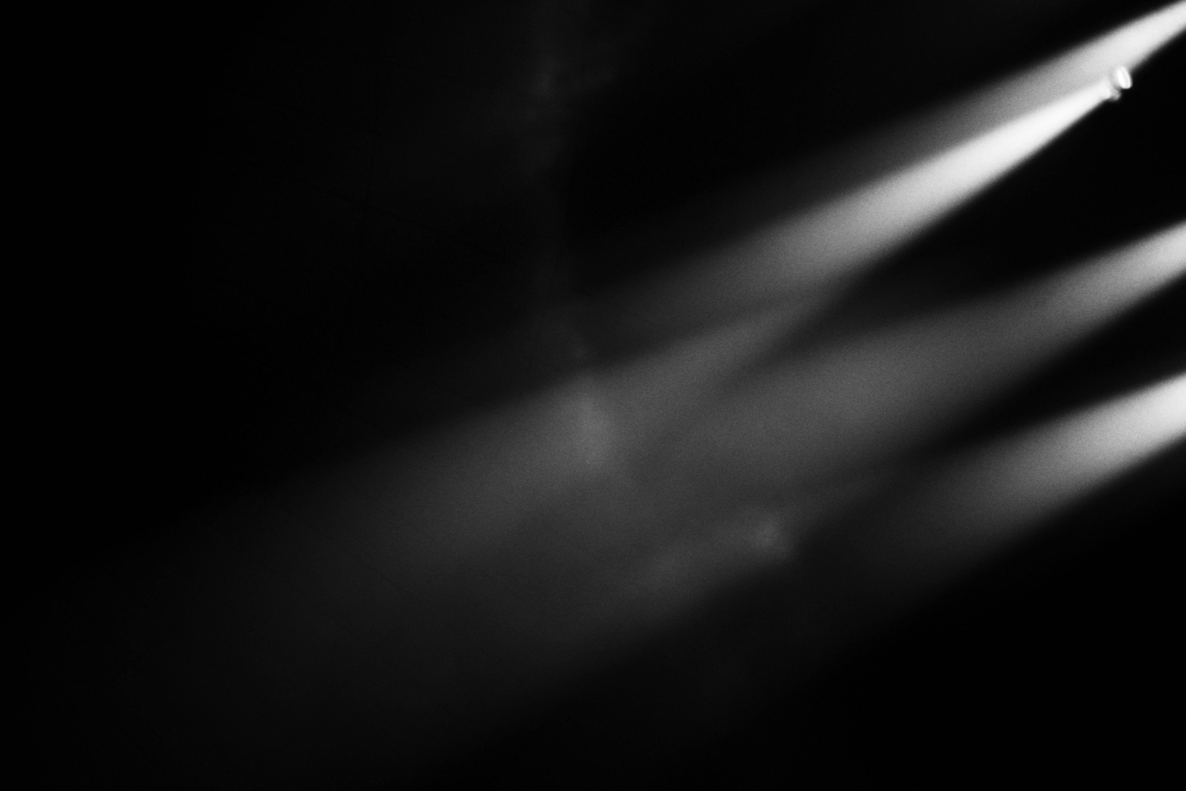 Stage lights shining through smoke on a dark background