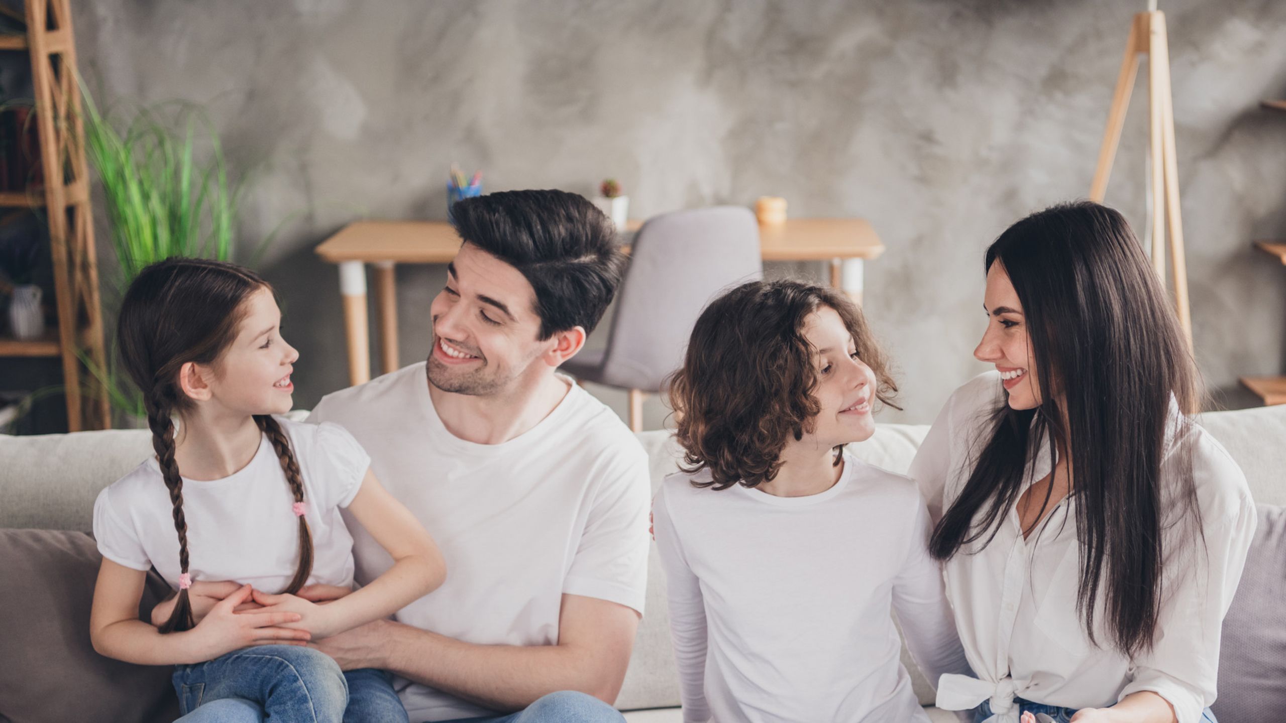 Image d'une famille souriante dans le confort de leur salon