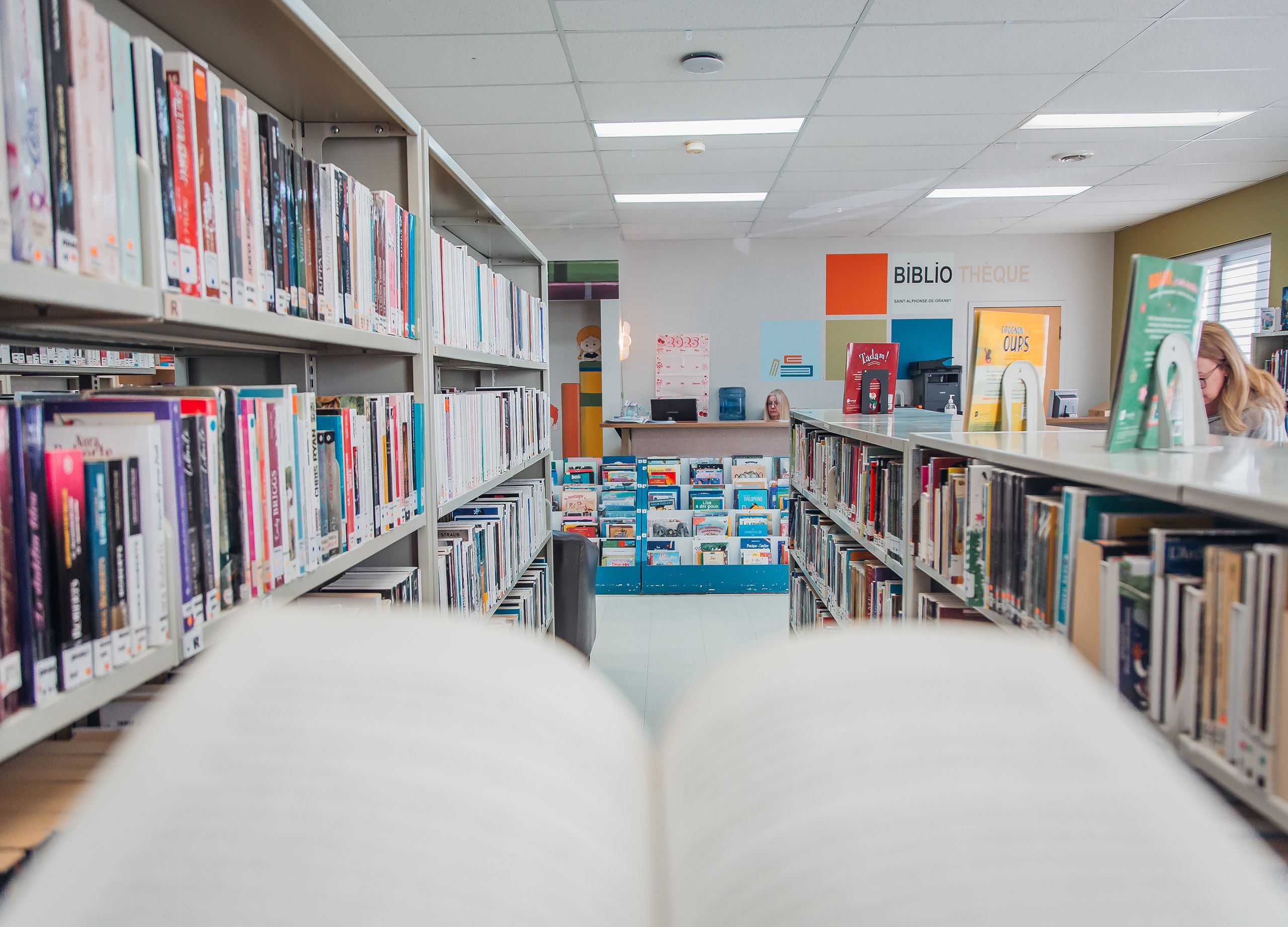 Livre ouvert et vue intérieure de la bibliothèque